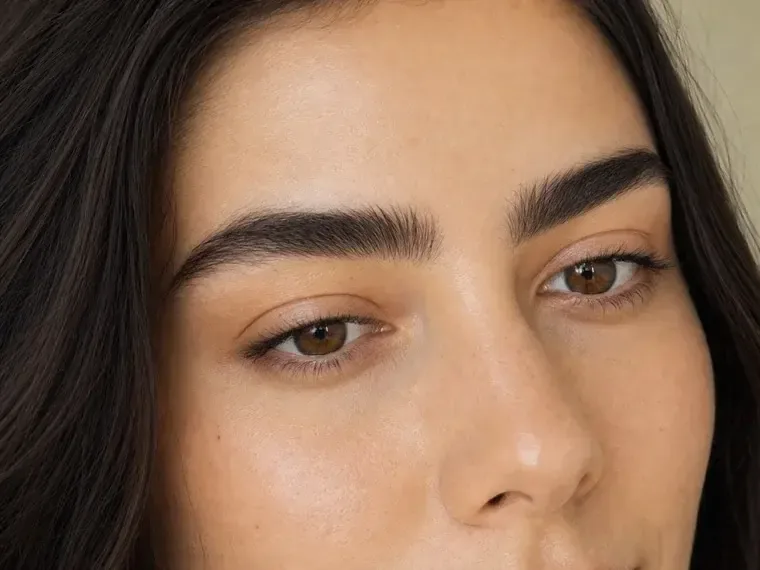Close-up of thick brows set in one direction